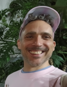 selfie of Diego Báez in a light shirt and cap.